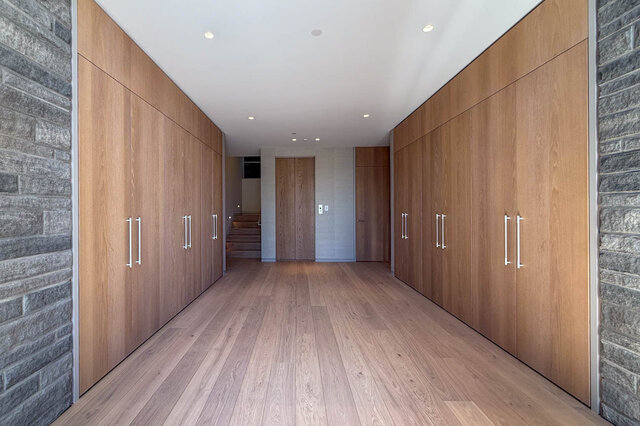 Hallway with hardwood floors and built-in wooden cabinets. - 2390 Westhill Drive, West Vancouver