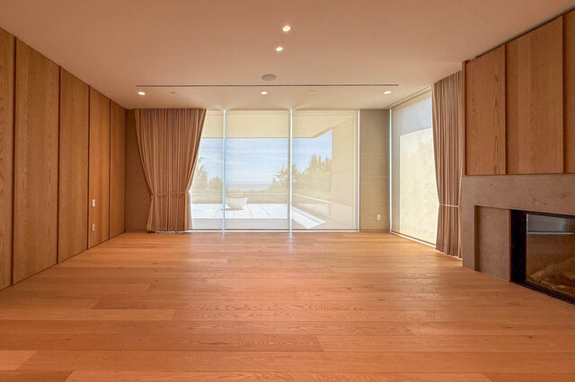 Spacious living room with hardwood floors and floor-to-ceiling windows overlooking trees. - 2390 Westhill Drive, West Vancouver