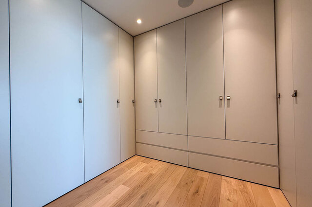 Walk-in closet with sleek built-in cabinets and light hardwood floors. - 2390 Westhill Drive, West Vancouver