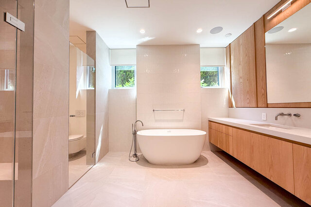 Bathroom with freestanding white tub and light wood cabinetry. - 2390 Westhill Drive, West Vancouver