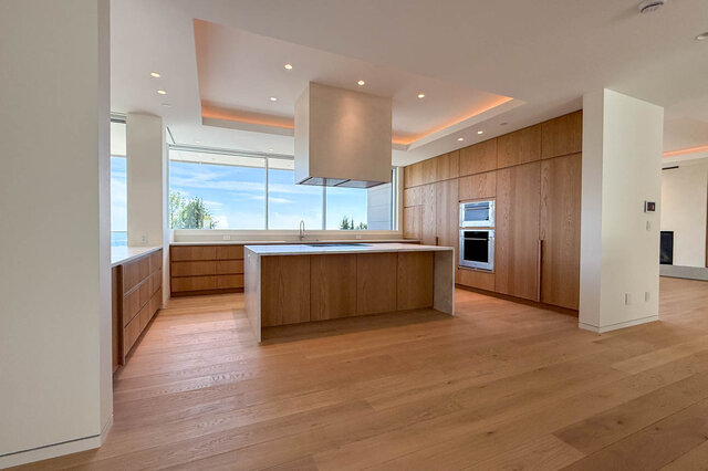 Modern kitchen with hardwood floors and large windows overlooking greenery. - 2390 Westhill Drive, West Vancouver