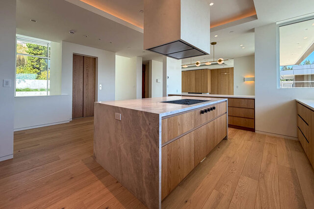 Modern kitchen with light stone countertops and hardwood floors. - 2390 Westhill Drive, West Vancouver