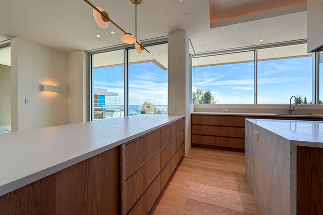Modern kitchen with large windows overlooking city views and hardwood floors. - 2390 Westhill Drive, West Vancouver