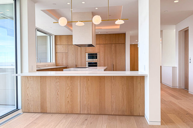 Modern kitchen with light wood cabinetry and hardwood floors. - 2390 Westhill Drive, West Vancouver