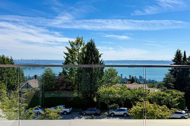 Balcony with panoramic water views and distant city skyline beyond lush greenery. - 2390 Westhill Drive, West Vancouver