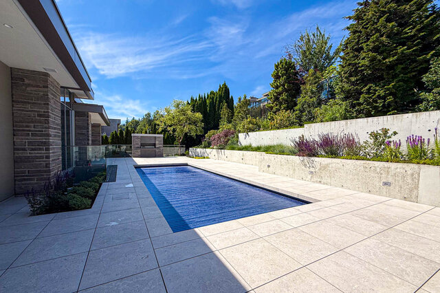 Backyard with long rectangular swimming pool and stone tile patio. - 2390 Westhill Drive, West Vancouver