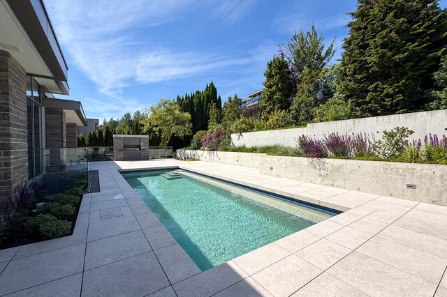 Pool deck with clear turquoise water and stone tile flooring. - 2390 Westhill Drive, West Vancouver