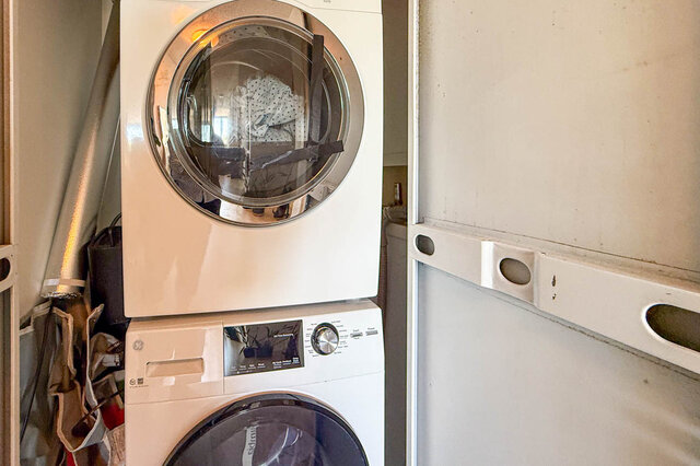 Laundry area with stacked white washer and dryer unit in compact space. - 501-550 Taylor Street, Vancouver Downtown