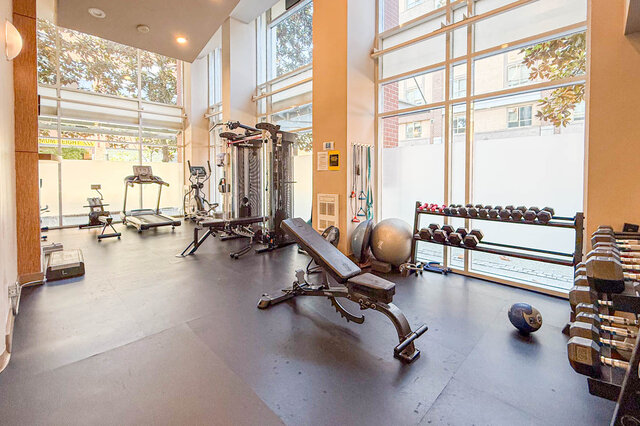 Spacious fitness center with large windows and organized dumbbell racks. - 501-550 Taylor Street, Vancouver Downtown