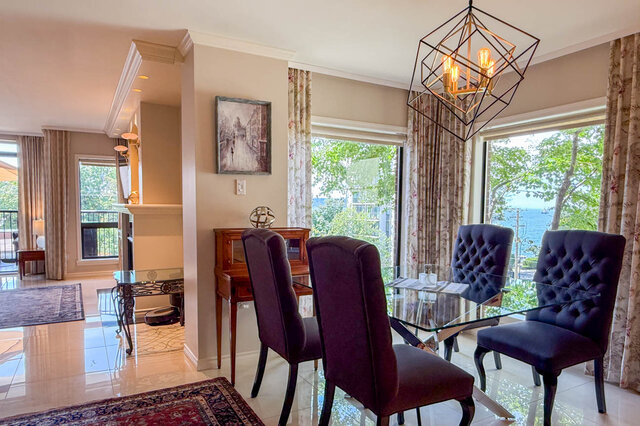 Dining area with glass-top table and ocean view through bay windows. - 302-1520 Harwood Street, Vancouver Downtown