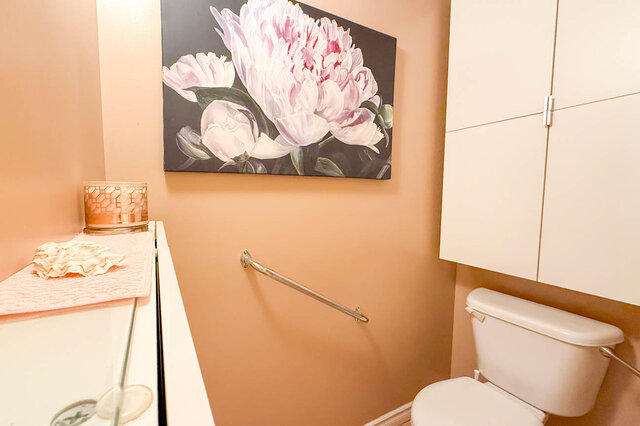 Bathroom with pink peony artwork above sink and peach-toned walls. - 302-1520 Harwood Street, Vancouver Downtown