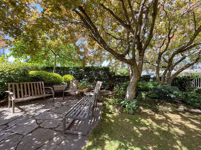 Outdoor patio with stone paving and shaded seating under mature trees. - 302-1520 Harwood Street, Vancouver Downtown