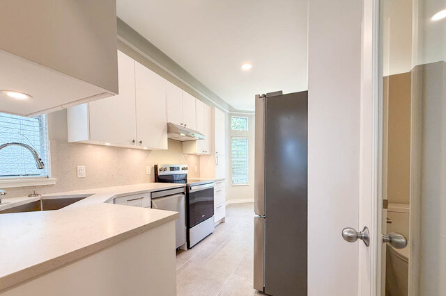 Front entry with wooden door and brick pathway leading to 2-bedroom + den duplex. - 3443 West 6th Ave, Vancouver West Side