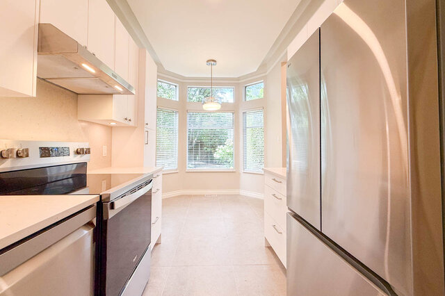 Spacious patio with wooden deck and large windows overlooking lush greenery. - 3443 West 6th Ave, Vancouver West Side