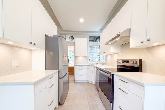 Bright kitchen with white cabinetry and stainless steel appliances. - 3443 West 6th Ave, Vancouver West Side