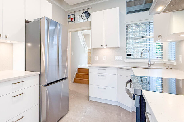 Spacious living room with hardwood floors and stone fireplace. - 3443 West 6th Ave, Vancouver West Side