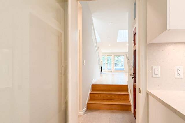 Spacious living room with hardwood floors and a bright skylight overlooking the balcony. - 3443 West 6th Ave, Vancouver West Side