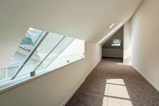 Spacious attic bedroom with large skylight and plush carpet flooring. - 3443 West 6th Ave, Vancouver West Side