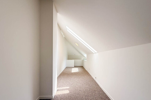 Bright loft bedroom with angled skylight windows and plush carpet flooring. - 3443 West 6th Ave, Vancouver West Side
