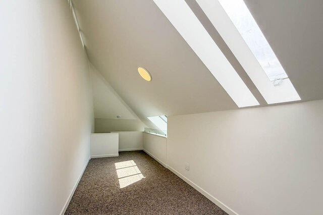 Attic space with panoramic views through angled skylights and plush carpeting. - 3443 West 6th Ave, Vancouver West Side