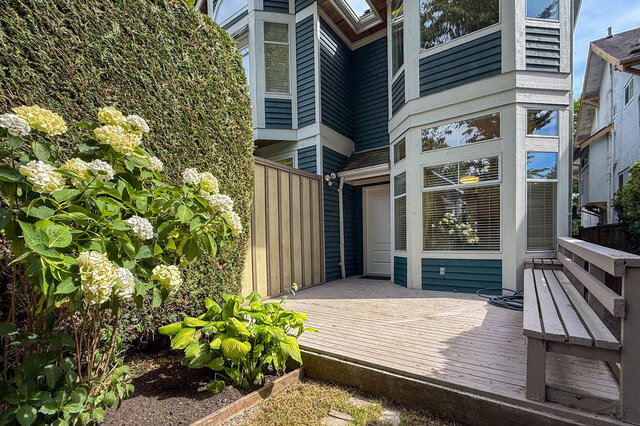 The entrance features a wooden deck, front door, large windows, garden with flowers, and a wooden bench. - 3443 West 6th Ave, Vancouver West Side