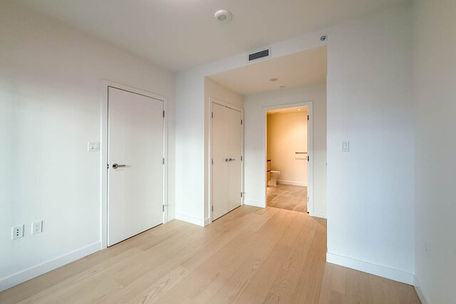 Bright hallway with light wood flooring and white walls. - 406-777 Harbour Way, North Vancouver