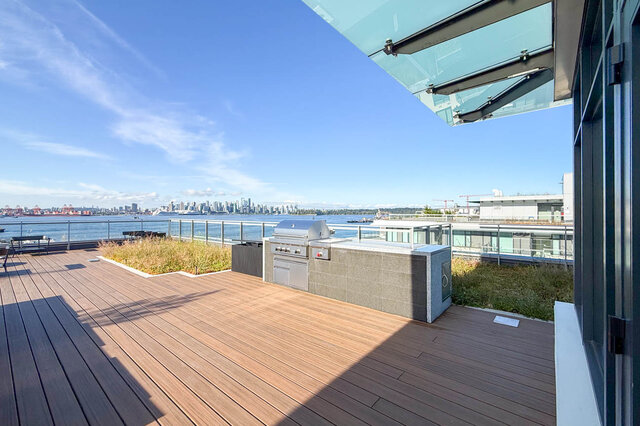 Rooftop patio with wooden deck and city view across the water. - 406-777 Harbour Way, North Vancouver