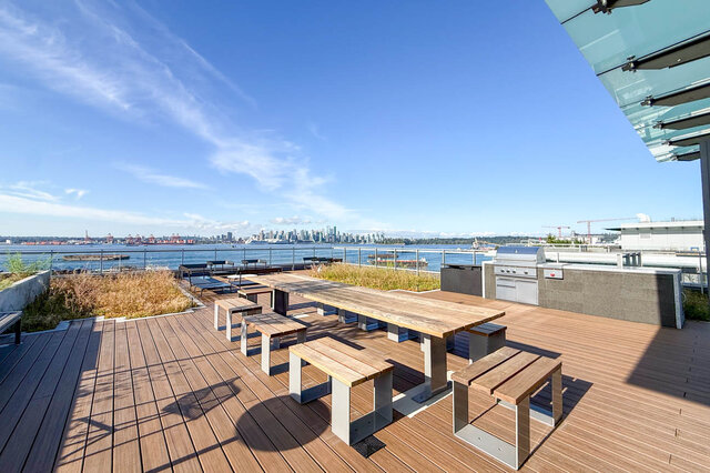 Rooftop patio with city view and wooden deck. - 406-777 Harbour Way, North Vancouver