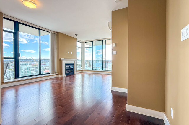 The living room has hardwood floors, a fireplace, floor-to-ceiling windows, and a city view. - 1601-155 1st Street West, North Vancouver