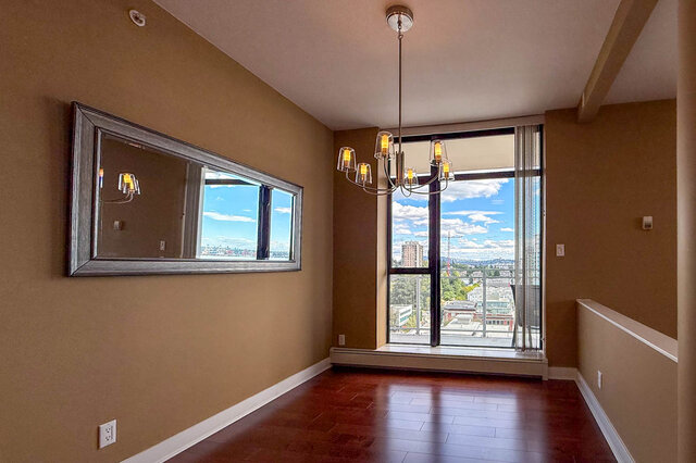 The living room has hardwood floors, large windows with city view, and a chandelier. - 1601-155 1st Street West, North Vancouver