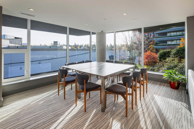 Bright dining space with panoramic city views and sleek stainless steel table. - 204-866 Arthur Erickson Place, West Vancouver