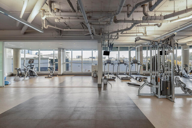 Gym with treadmills and city views through large windows. - 204-866 Arthur Erickson Place, West Vancouver