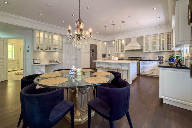 A spacious kitchen with a glass-top dining table and crystal chandelier - 1249 Chartwell Place, West Vancouver
