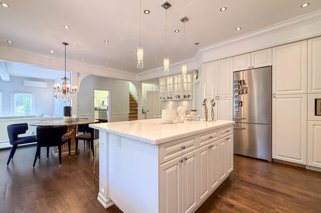 A bright, modern kitchen with white cabinetry, stainless appliances, and a central island - 1249 Chartwell Place, West Vancouver