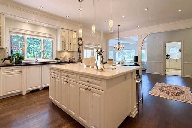 A bright, spacious kitchen with white cabinetry, large windows, and a central island - 1249 Chartwell Place, West Vancouver
