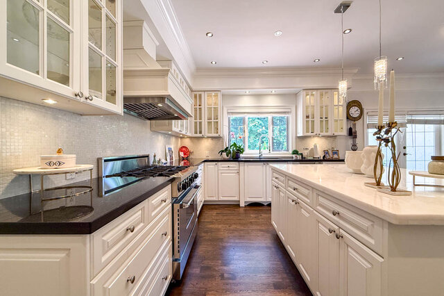 A bright, spacious kitchen with white cabinetry, stainless steel appliances, and a large island - 1249 Chartwell Place, West Vancouver