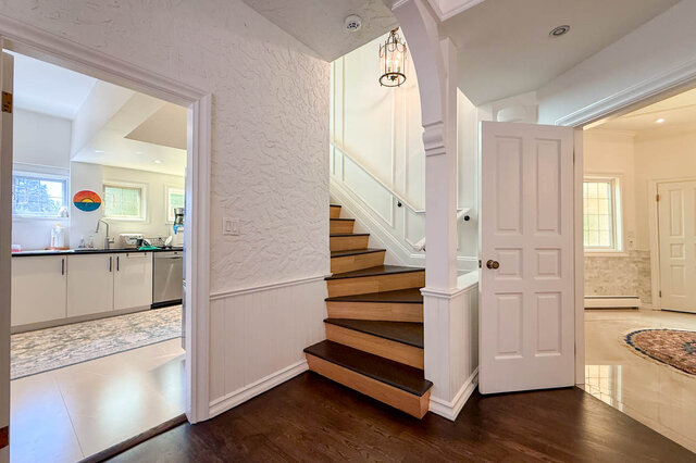 Bright hallway with hardwood floors, wainscoting, and a staircase. - 1249 Chartwell Place, West Vancouver