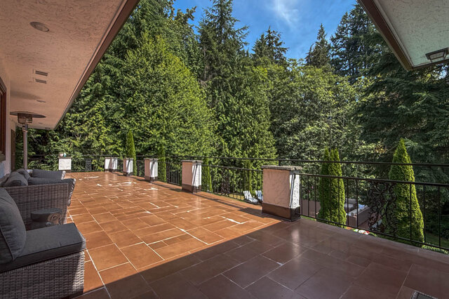 A sunny balcony with tiled flooring and lush greenery - 1249 Chartwell Place, West Vancouver