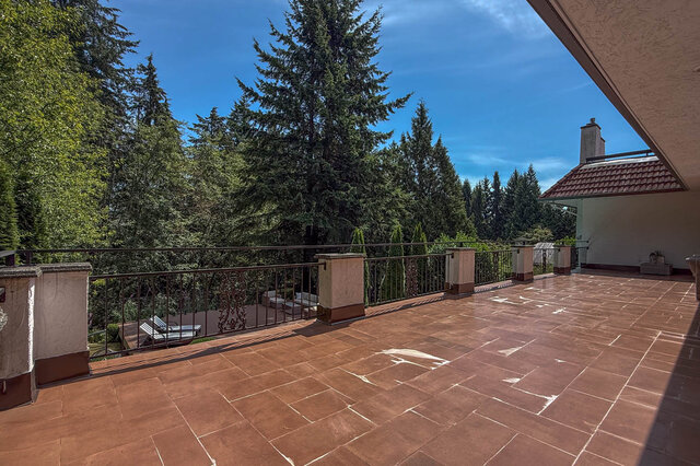 Sunny balcony overlooking a forest with tiled flooring and metal railing - 1249 Chartwell Place, West Vancouver