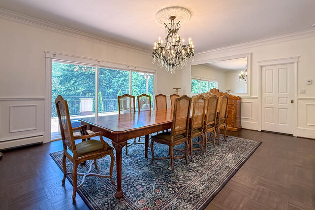 Spacious dining area with hardwood floors, a large table, and large windows overlooking greenery - 1249 Chartwell Place, West Vancouver