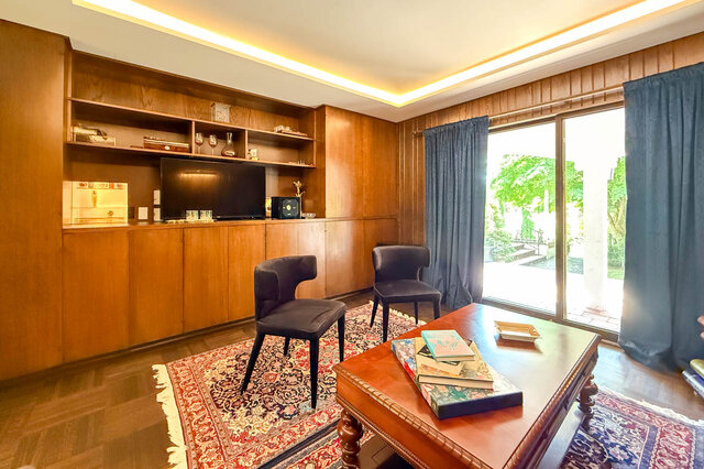 A bright living room with wooden cabinetry, large windows, and a patterned rug - 1249 Chartwell Place, West Vancouver
