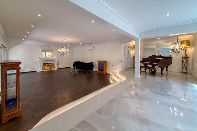 A spacious, elegant living room with a grand piano, fireplace, and chandeliers - 1249 Chartwell Place, West Vancouver