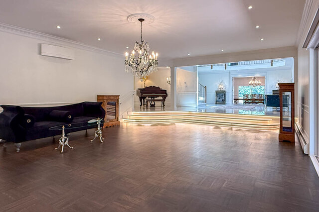 Spacious formal living room with hardwood floors, a crystal chandelier, and a grand piano - 1249 Chartwell Place, West Vancouver