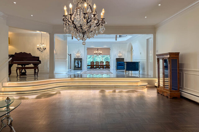 A spacious, elegantly appointed living room with hardwood floors, chandeliers, and a grand piano - 1249 Chartwell Place, West Vancouver