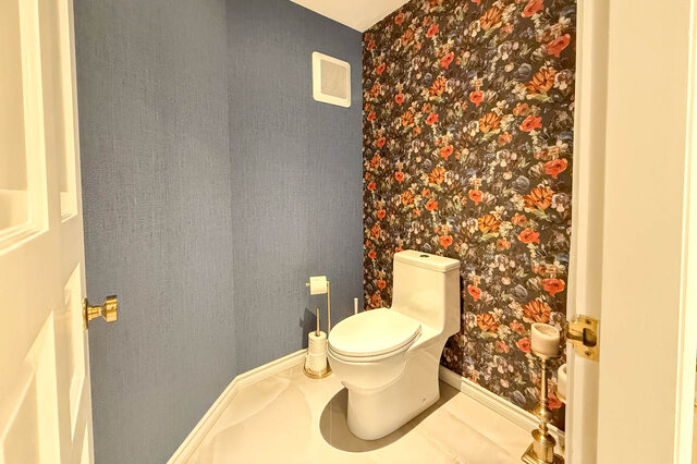 A well-lit bathroom with floral wallpaper and blue walls - 1249 Chartwell Place, West Vancouver