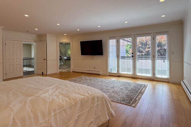 Spacious bedroom with hardwood floors, recessed lighting, and large sliding glass doors - 1249 Chartwell Place, West Vancouver