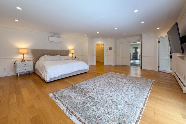 Spacious bedroom with hardwood floors, large area rug, and neatly made bed - 1249 Chartwell Place, West Vancouver