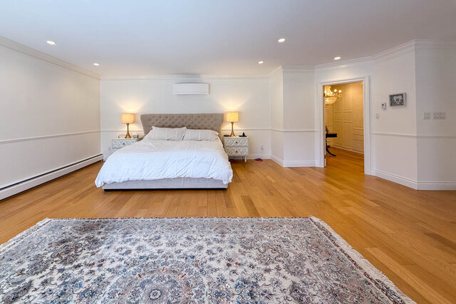 Spacious bedroom with hardwood floors and a large area rug. - 1249 Chartwell Place, West Vancouver