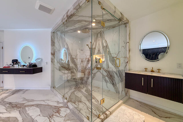 A luxurious bathroom with marble shower enclosure, dark wood vanity, and round mirrors - 1249 Chartwell Place, West Vancouver