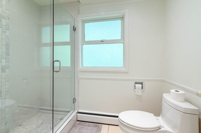 Clean, well-lit bathroom with glass shower enclosure and frosted window. - 1249 Chartwell Place, West Vancouver